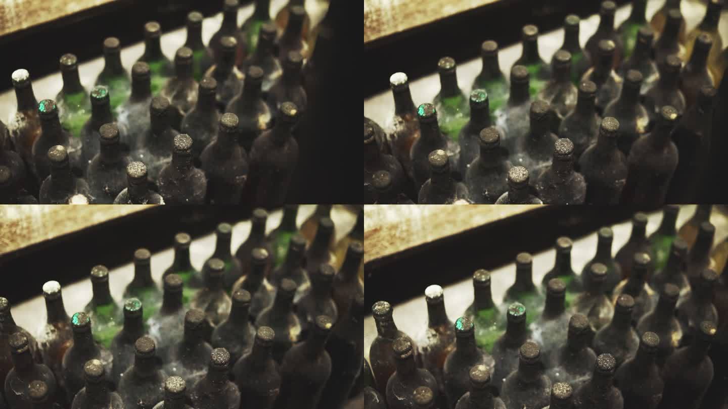 酒窖里一堆积满灰尘的旧酒瓶的特写