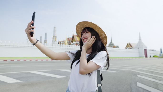 年轻的亚洲女性在泰国曼谷的曼谷大皇宫旅行时自拍。