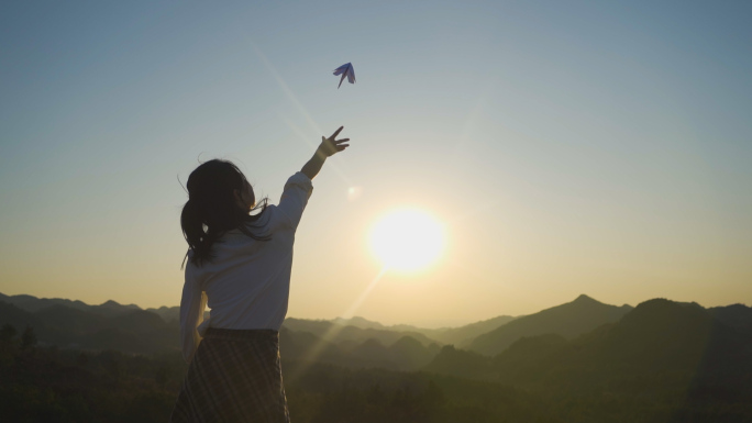 白衬衫女生山顶扔纸飞机放飞梦想未来可期