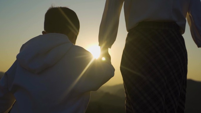 妈妈陪伴小孩大手牵小手母子剪影亲子背影