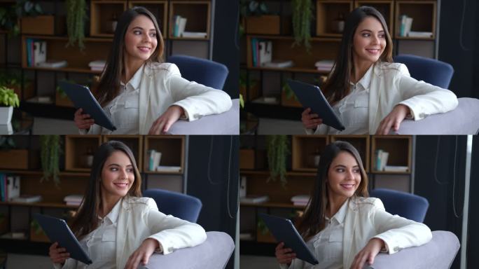 办公室休息室里一位美丽的年轻女士拿着一块平板电脑，然后神情凝重地微笑着
