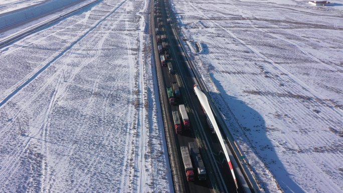 俯拍雪后高速公路风机叶片运送