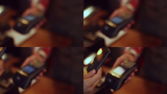 一位面目全非的女士在餐厅用智能手机付款的特写镜头。