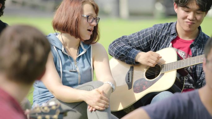 大学生操场户外活动弹吉他唱歌校园生活