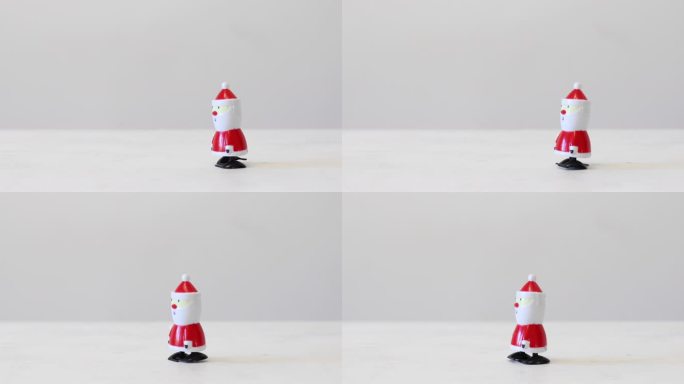卷起，塑料圣诞老人玩具走过一张白色桌子，有复制空间