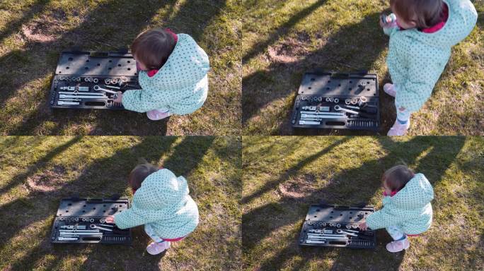 孩子在日落时玩汽车修理工具。女机械师。