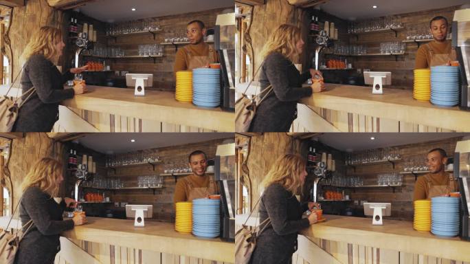 男咖啡师在咖啡厅柜台为女性准备咖啡