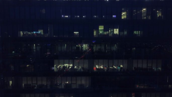 夜间摩天大楼的鸟瞰办公室窗户