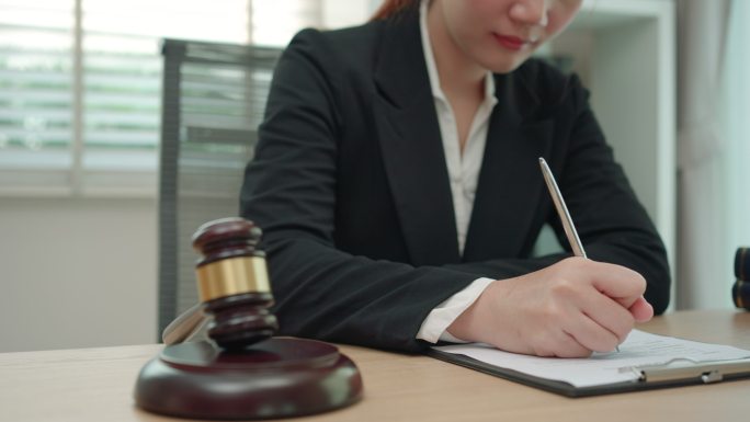 在办公室工作的女律师和公证员在文件上签字。顾问律师、司法和法律、律师、法院法官、概念。