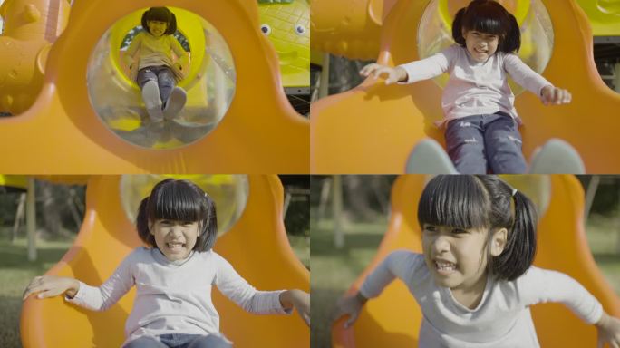 一个快乐的女孩在黄色滑梯上滑过洞的正面镜头