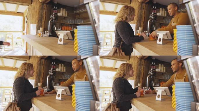 咖啡师在咖啡厅柜台为顾客提供咖啡