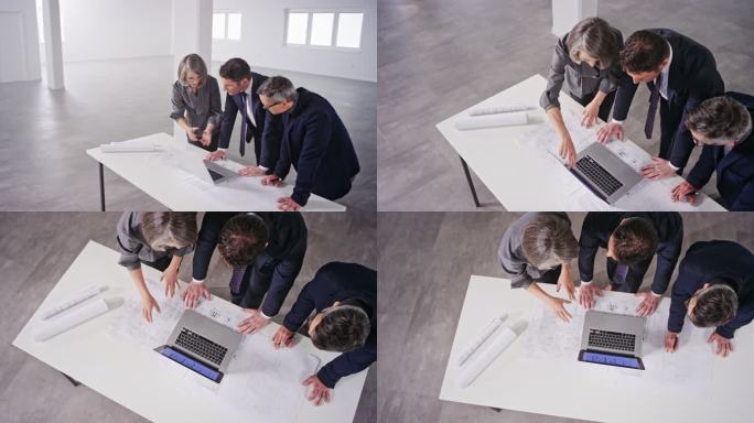 CS女室内设计师和她的男同事建筑师向男投资者解释笔记本电脑空间的设计