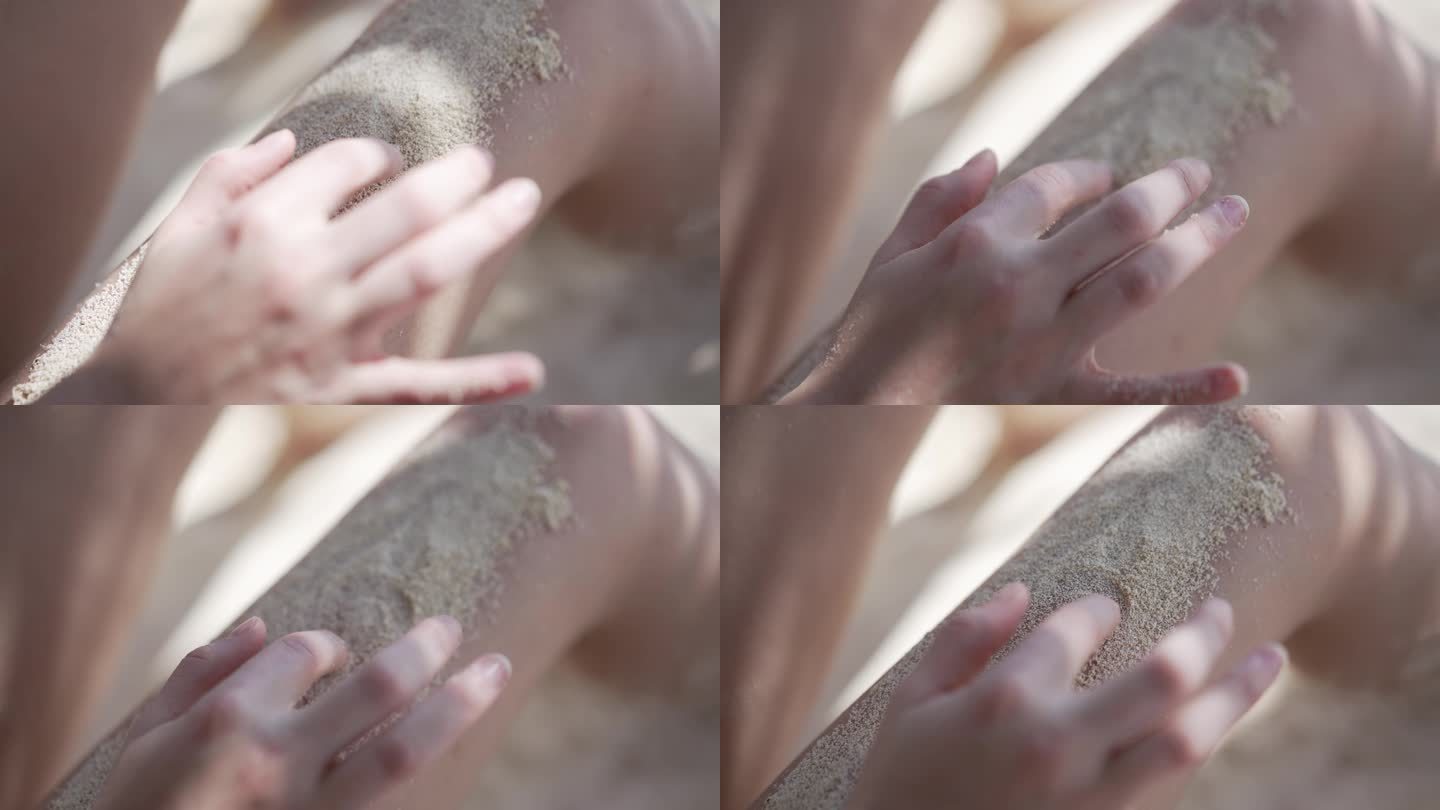 一名女子在被沙子覆盖的腿上画心