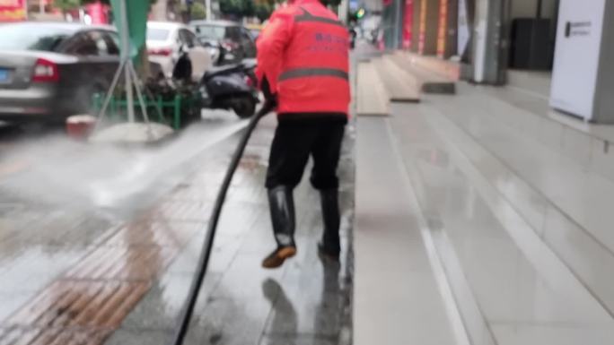 洪水过后环卫工人清扫冲洗街道洒水车作业