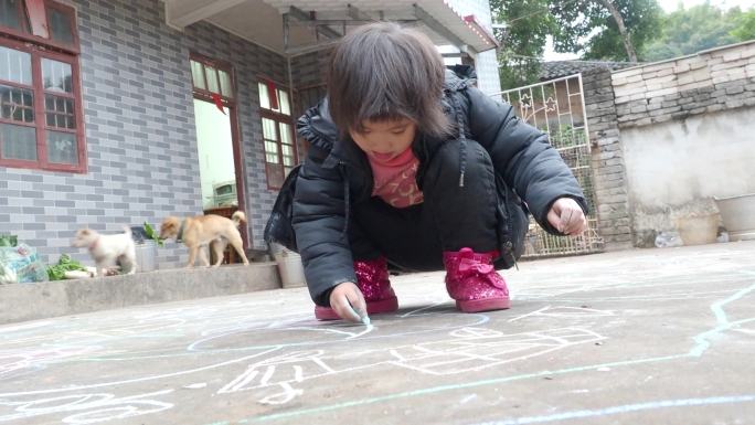 农村小孩子在庭院粉笔涂鸦画画