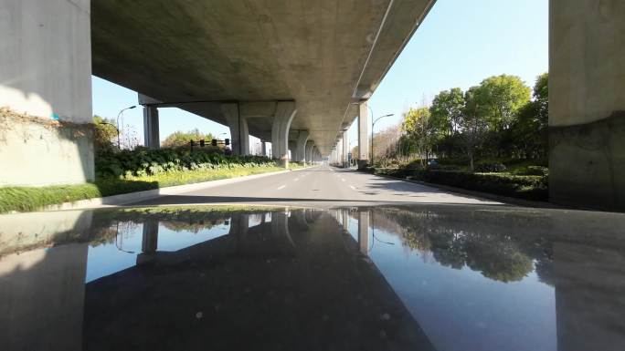 驾驶汽车行驶在高架桥下地面道路