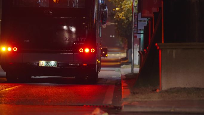 夜晚城市马路两人赶上公交车后离开。