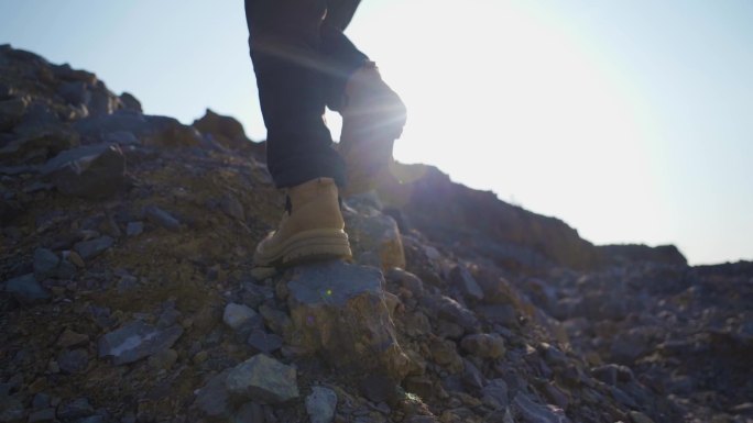 登山脚步特写逆光行走背影爬山脚步登山鞋