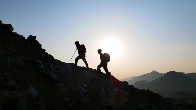 团队逆光登山剪影爬到脚步攀登顶峰团队协作