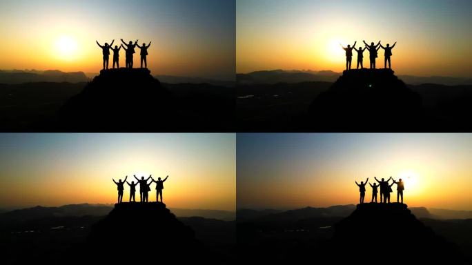 一群人登上山顶在山顶逆光拥抱太阳梦想蓝天