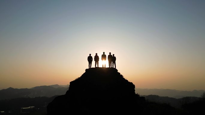 团队登山登山成功站在山顶眺望远方庆祝胜利