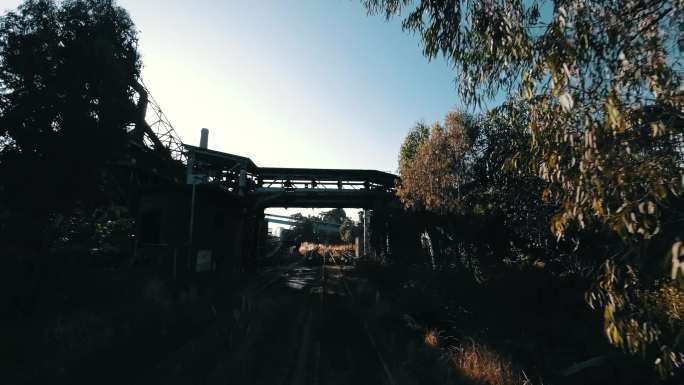 穿越机FPV航拍火车穿过树林看见废弃工厂