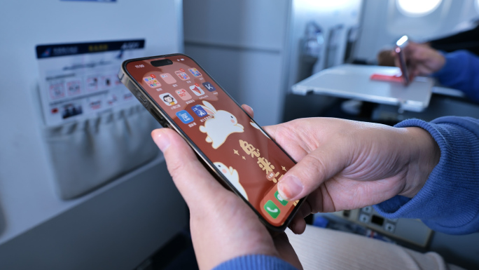 飞机上乘客玩手机刷新闻使用手机刷手机