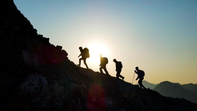 团队登山剪影攀登顶峰逆光爬山人物剪影行者