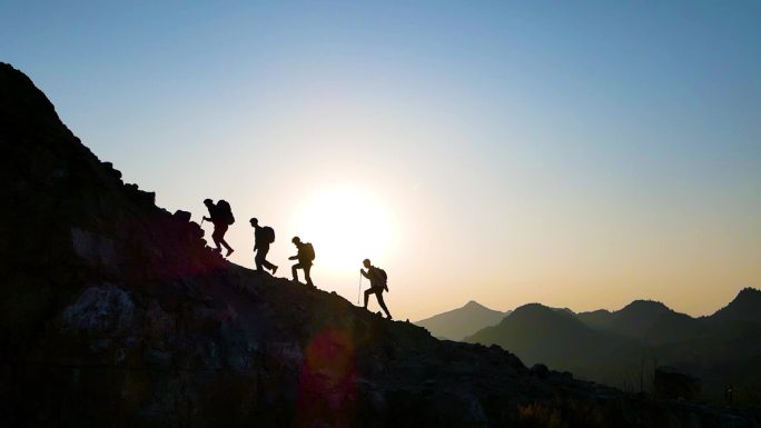 一群人走向山顶团队登山背影逆光人物剪影
