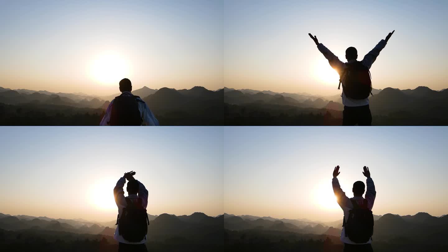 登山逆光人物背影特写山顶奔跑 张开双手