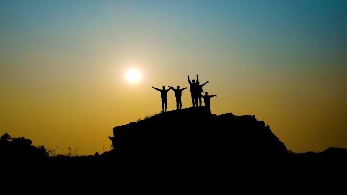一群人站在山顶挥手剪影大气团队背影攀登者