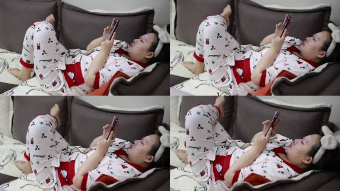 女孩躺在沙发玩手机