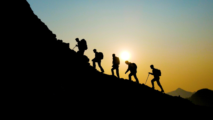 一群人登山剪影团队精神攀登山峰逆光行走