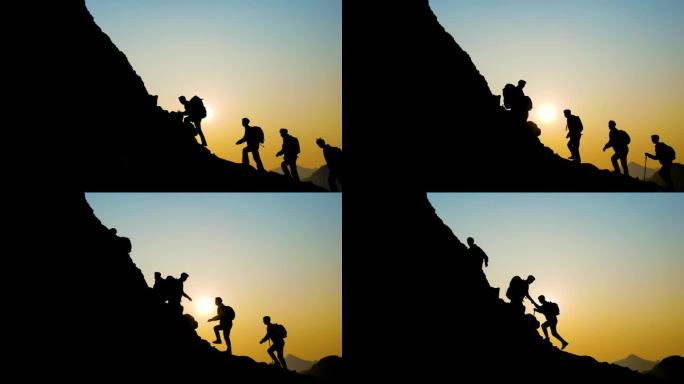 团队登山拉手瞬间逆光人物剪影攀登山峰意境