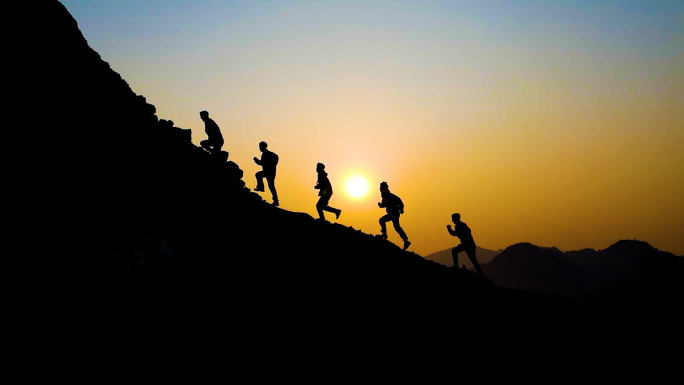一群人跑向山顶团队登山剪影逆光爬山背影