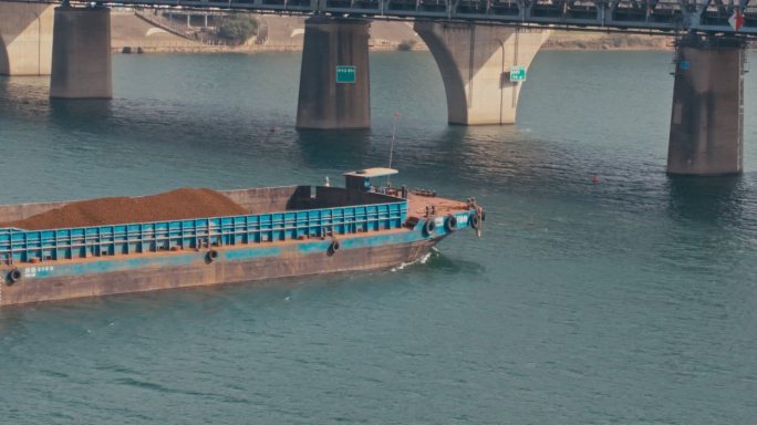 一只挖沙船在江中行驶 挖沙船穿过桥梁