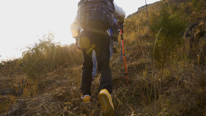 团队爬山背影逆光登山脚步团队力量徒步旅行