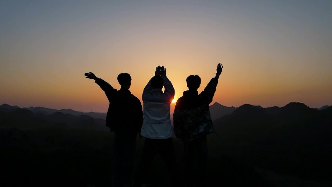 一群人山顶背影特写登山举手欢呼