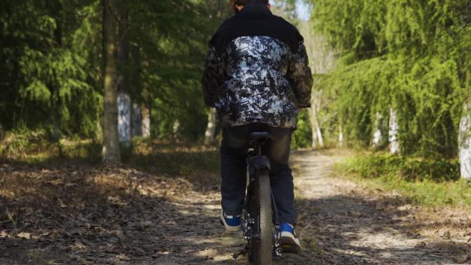 少年骑自行车穿过林间小道户外骑行爱好者