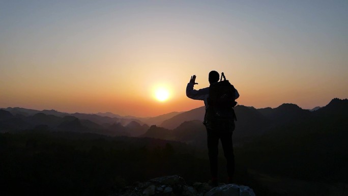 山顶夕阳人物背影特写 高声呐喊