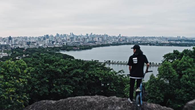 小轮车手在宝石山上俯瞰杭州城市