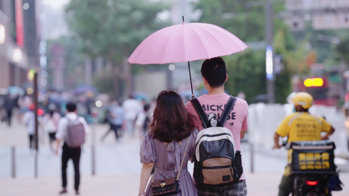 情人节下雨天撑伞约会的情侣