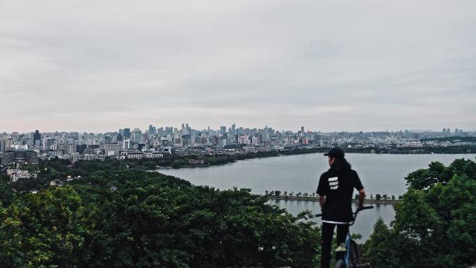 小轮车手在宝石山上俯瞰杭州城市