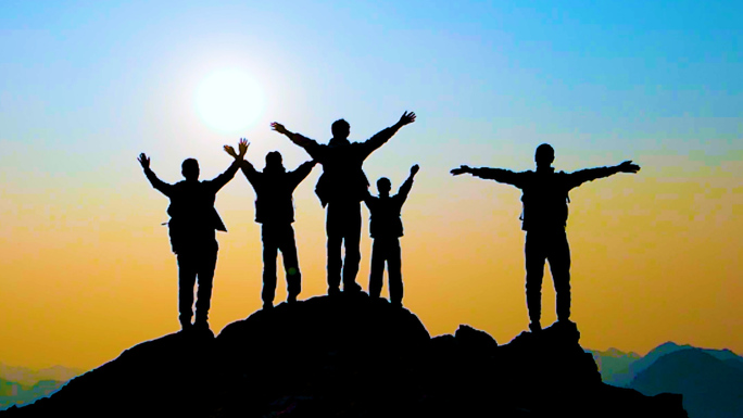 一群人登山剪影山顶举手欢呼团队精神攀登者