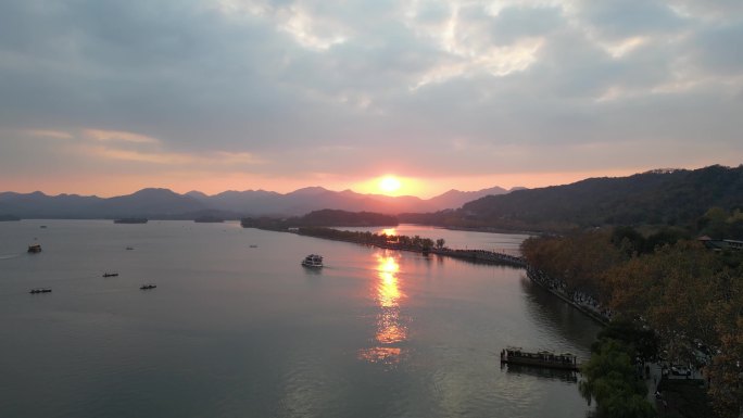 杭州西湖在夕阳下，游船在晚霞中行走