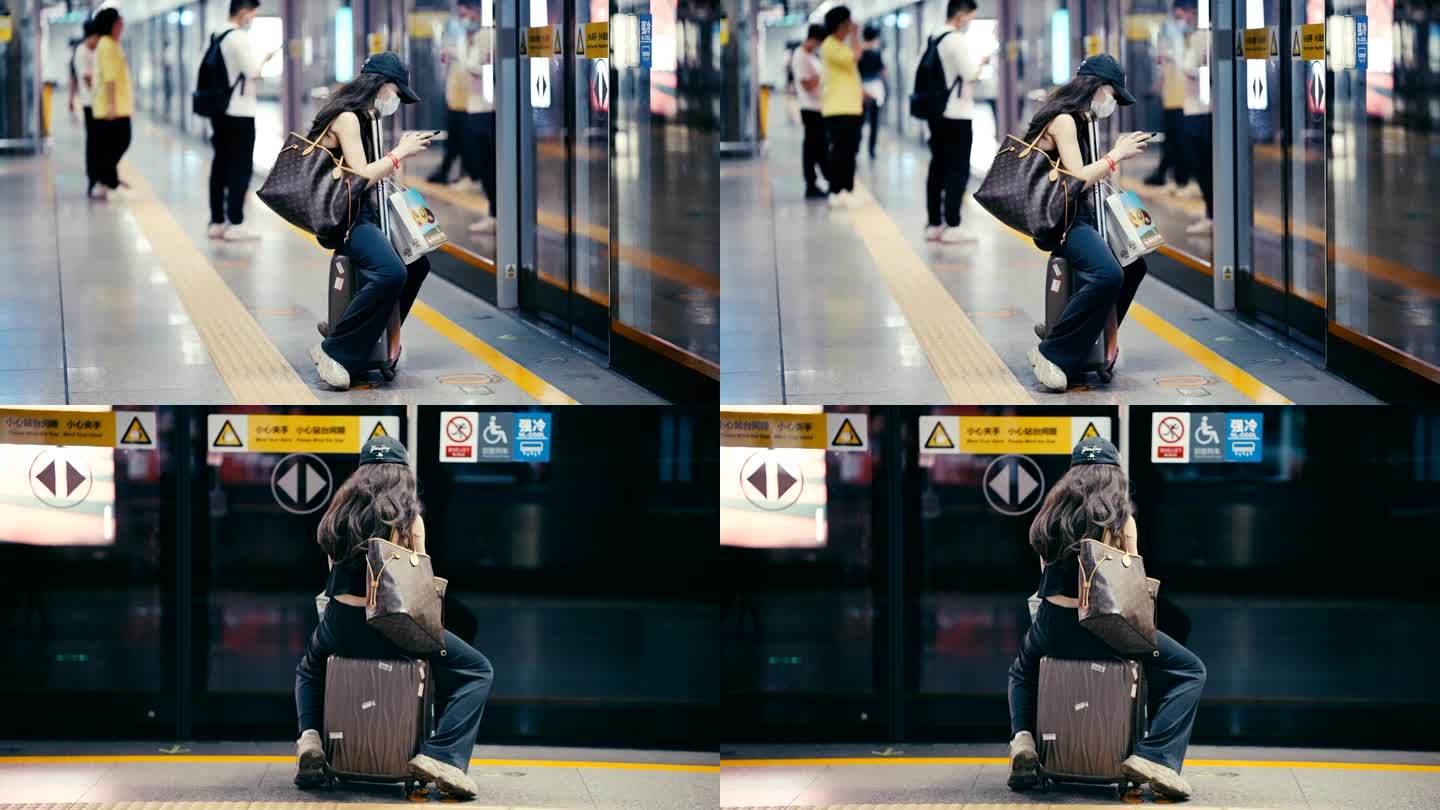 坐在行李箱等地铁的女子