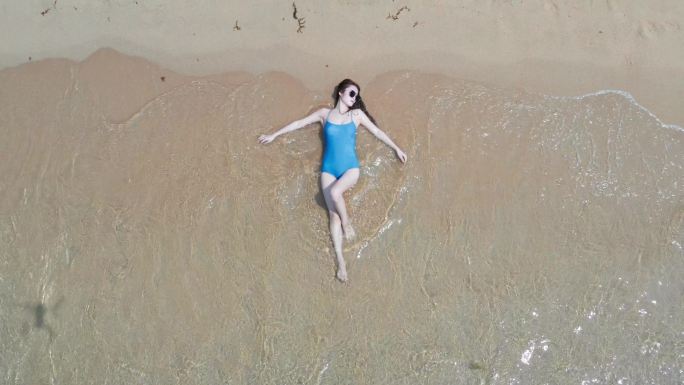 躺在海岛沙滩上晒太阳的女子