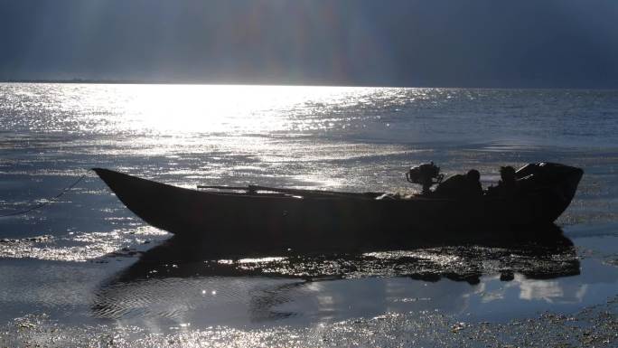 日落夕阳余晖大理洱海渔船在水中飘游