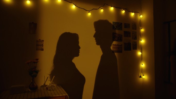 墙上光影下的情侣对视影子
