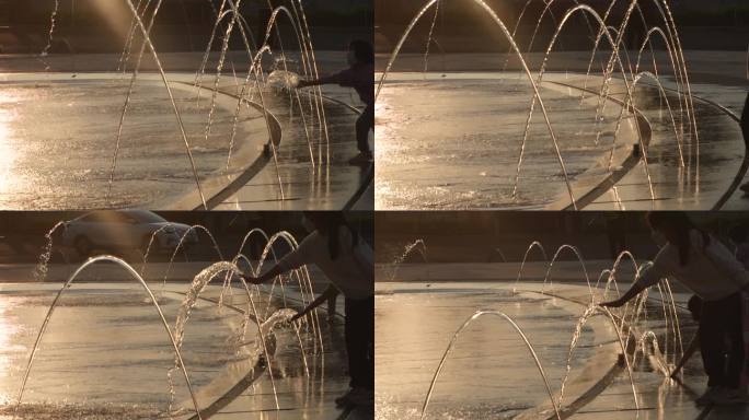 夕阳中的喷泉喷水小孩玩耍慢动作